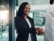 Businesswoman shakes hands with a colleague